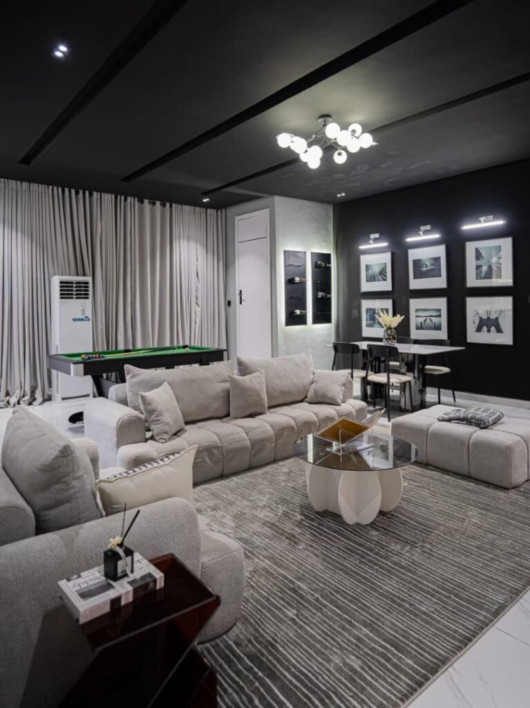 Modern living room with grey sectional sofa and snooker table in a luxury 2-bedroom apartment off Freedom Way, Lekki