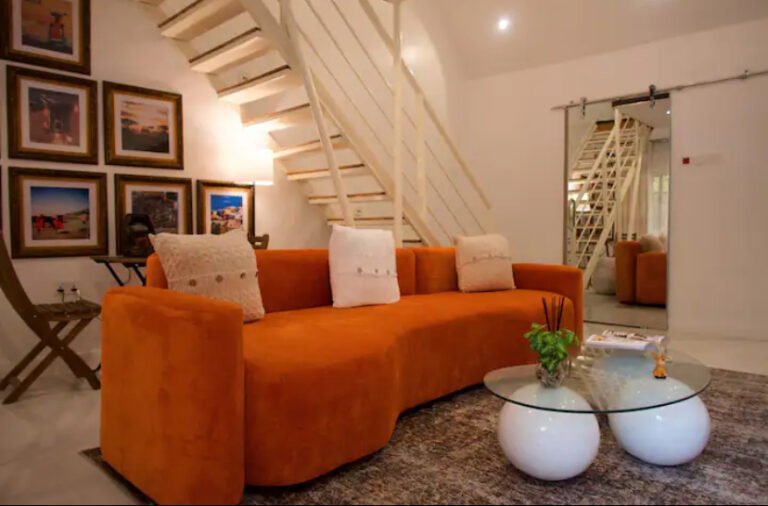 Luxury one-bedroom loft in Ikoyi featuring a stylish living area with an orange sofa and modern décor
